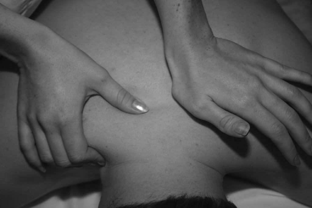 A client getting a massage before an acupuncture treatment for lower back pain.